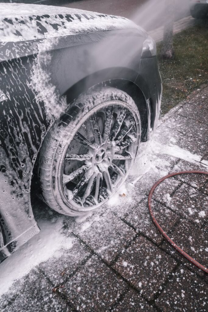 Mastering the First Impression: Your intriguing post title goes here Close-up of a luxury car wheel being thoroughly washed with foam outdoors.